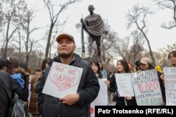 Әйел құқығын қорғауға арналған митингіде "Жалғыз емессіздер!" деген жазу ұстап тұрған ер адам. Алматы, 8 наурыз, 2023 жыл.