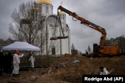 Киевтің іргесіндегі Буча қаласында қаза тапқан адамдарды Ресей әскері кеткеннен кейін бауырластар зиратынан қазып алып жатыр. Мәйітханада зерттеу жүргізеннен кейін марқұмдарды қайта жерлейді. Украина, 10 сәуір 2022 жыл.