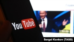 Програма YouTube у смартфоні на тлі відео з виступом президента РФ Володимира Путіна. Ілюстративне фото