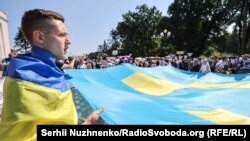 Акція під Верховною Радою України. Люди написали побажання на великому кримськотатарському прапорі, який пізніше запустили до Дня кримськотатарського прапора. Київ, 15 червня, 2021 року