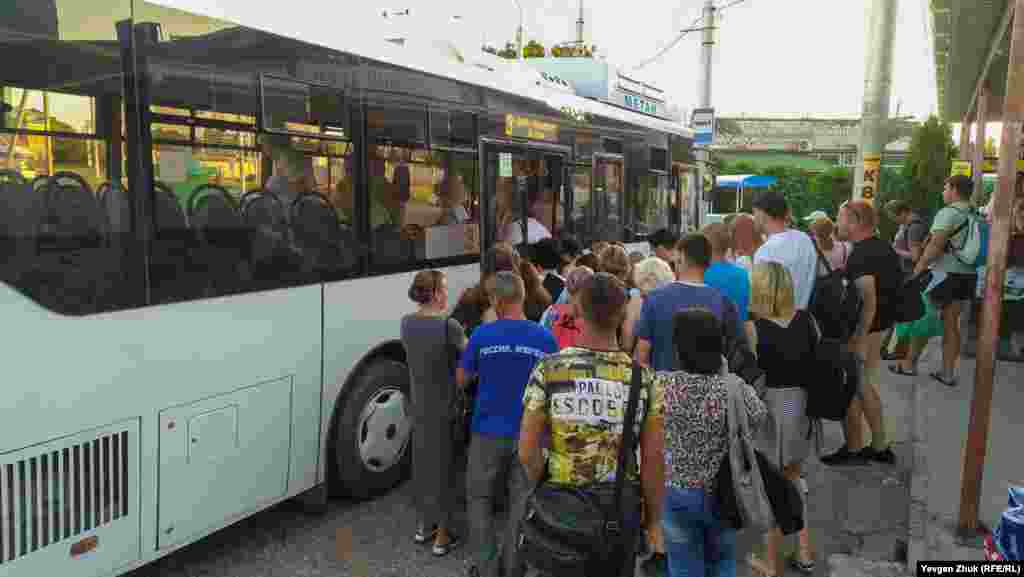 На вході в автобус люди товпляться, не дотримуючись соціальної дистанції